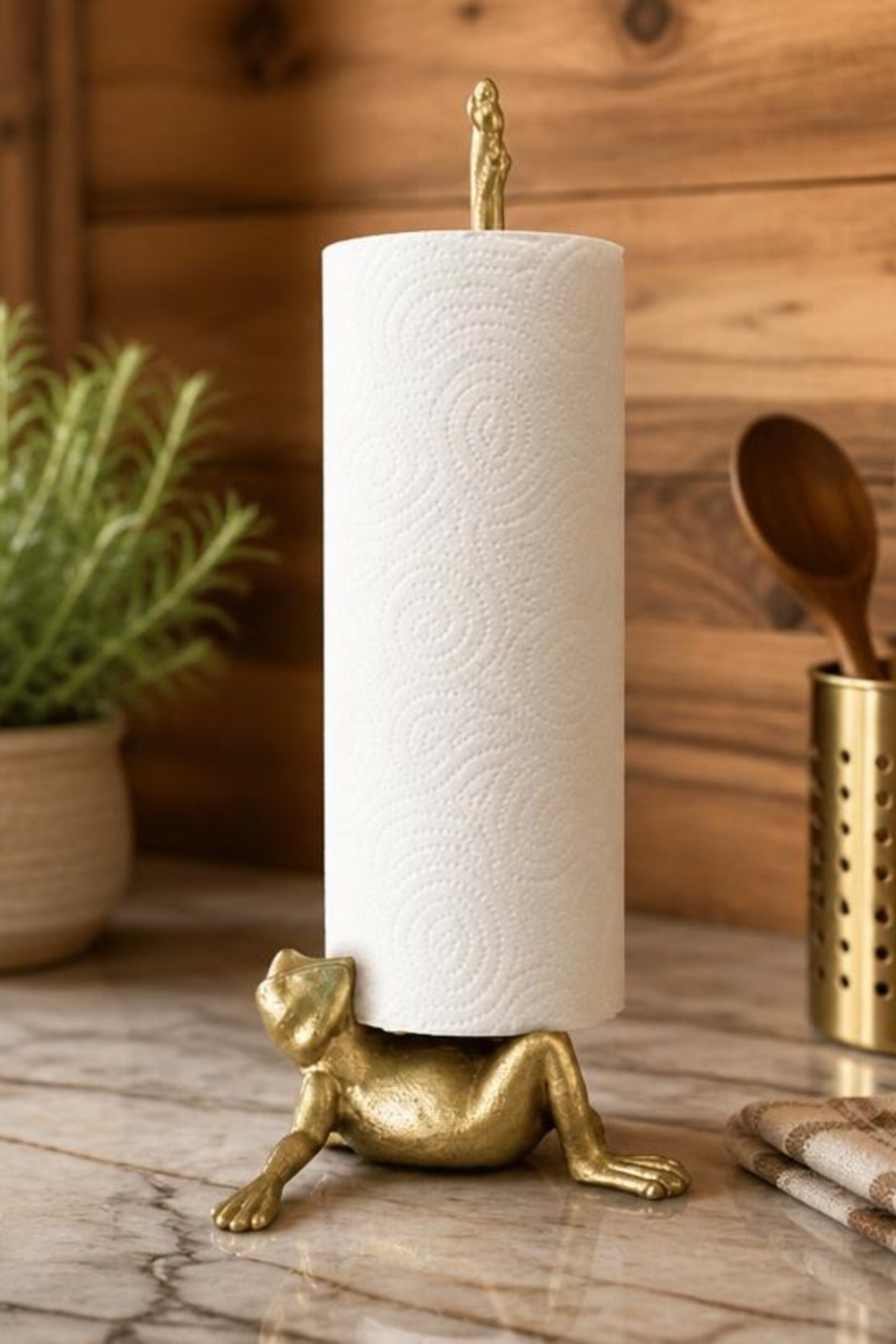 Gold cast-iron frog-shaped paper towel holder on a marble cabin kitchen countertop