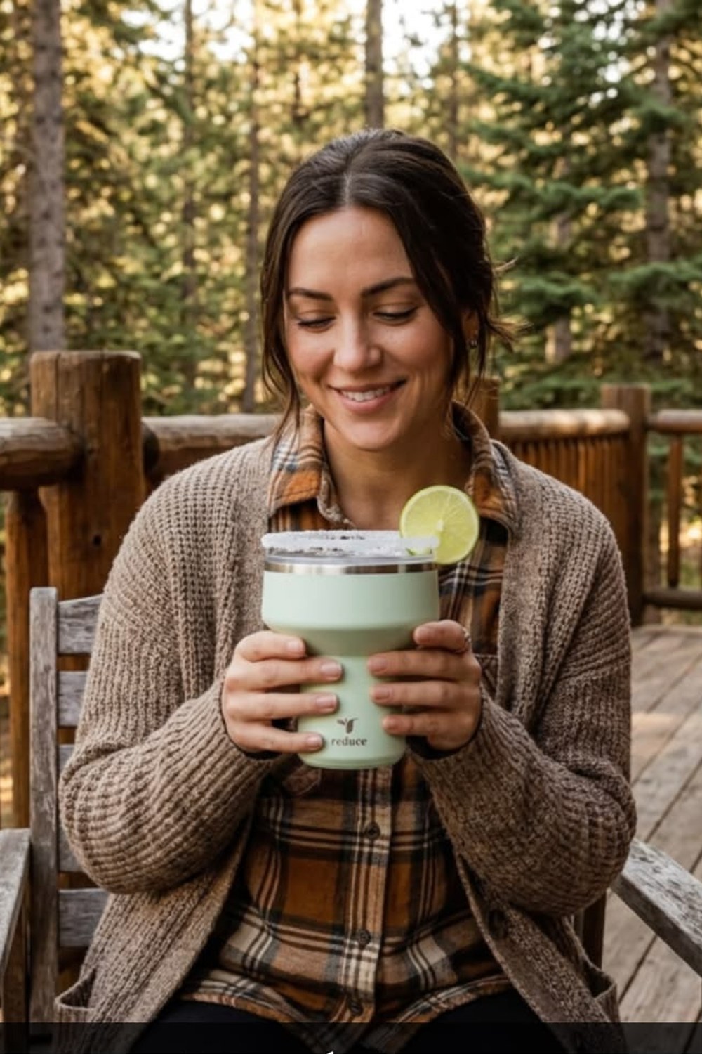 Sea-glass green REDUCE Saltini insulated cocktail tumbler with a margarita and lime, held on a cabin porch
